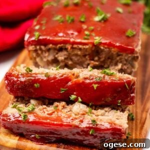 Classic Ritz-Crusted Meatloaf Recipe for Tender, Savory Results 11 Meatloaf on a cutting board garnished with fresh parsley. Two one-inch slices are cut off the loaf.