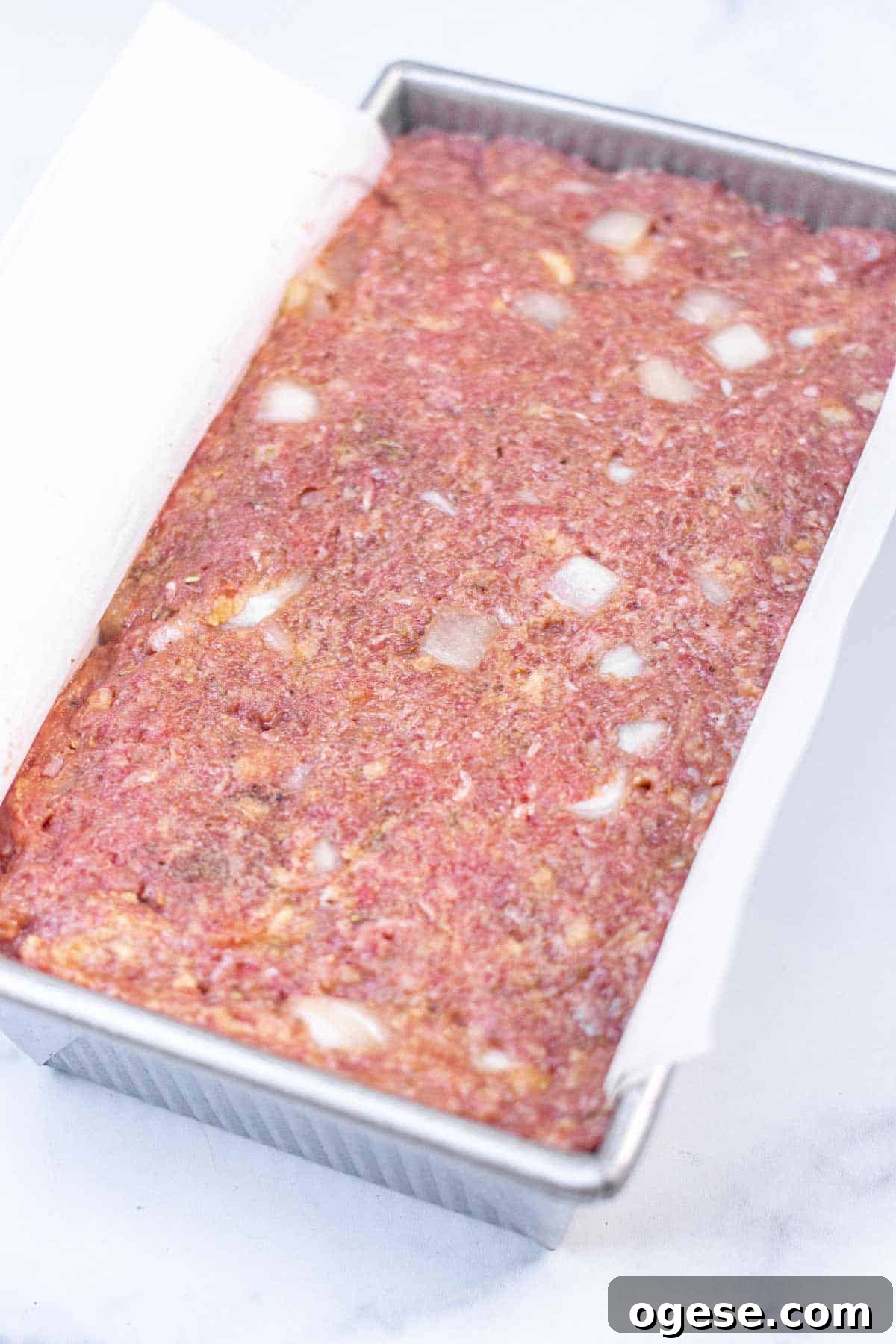 Classic Ritz-Crusted Meatloaf Recipe for Tender, Savory Results 6 Uncooked meatloaf mixture in a parchment lined loaf pan, firmly packed.
