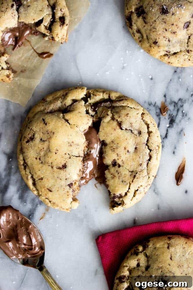 Nutella-Filled Chocolate Chip Cookies 7 Nutella stuffed cookies, broken open to show Nutella stuffing