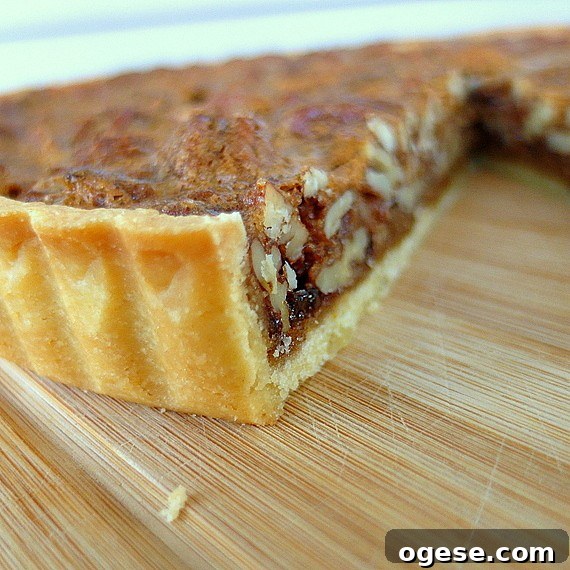 Coffee Pecan Tart with Orange Shortbread Crust Recipe 2 A close up of baked orange sable tart dough filled with pecan filling.