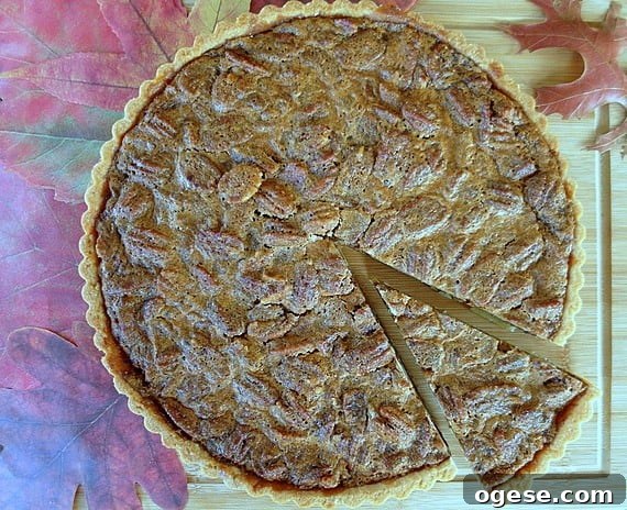 Coffee Pecan Tart with Orange Shortbread Crust Recipe 3 A whole pecan tart with one slice cut from it.