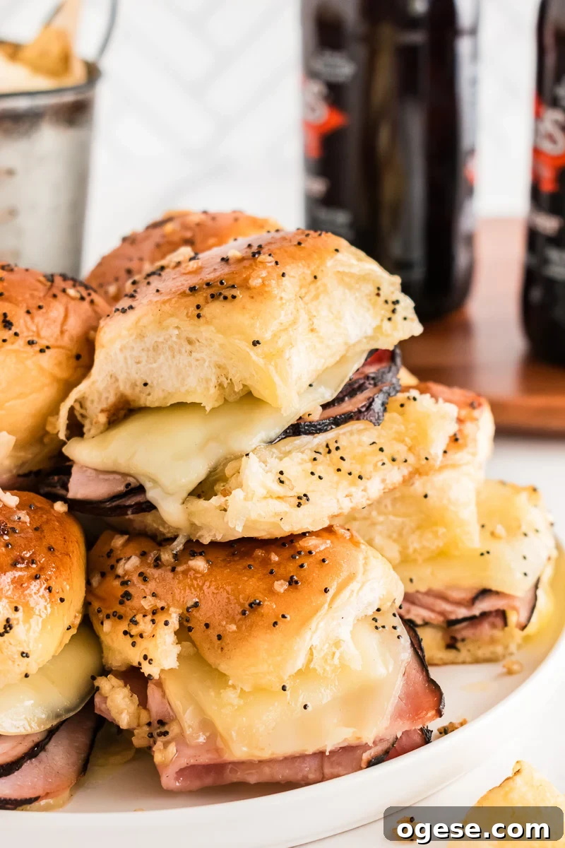 Ultimate Cheesy Ham and Melted Cheese Sliders Recipe 5 Side view of sliders stacked on a plate.