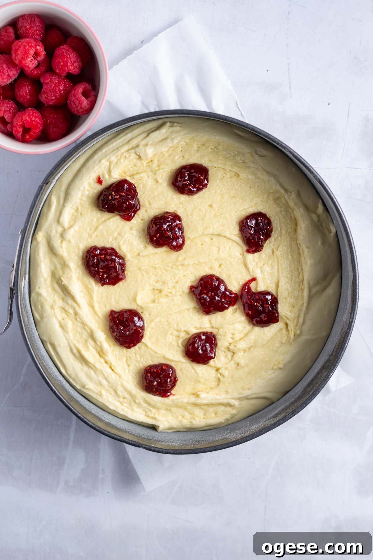 raspberry jam dolloped over cake batter