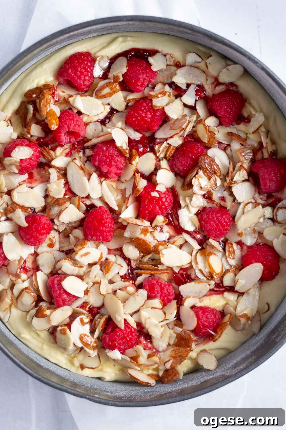 almond slices and fresh raspberries over the cake batter in a springform pan