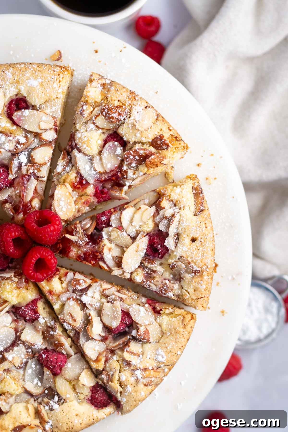 slices of raspberry almond cake on a cake stand