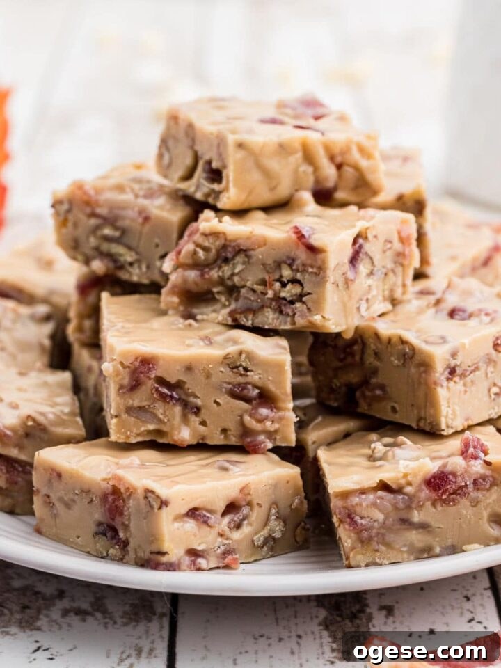 a plate full of maple bacon fudge with a maple leaf in the background and some bacon slices