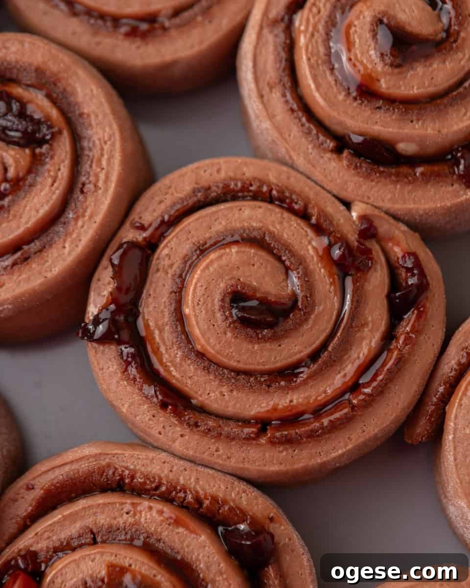 Close-up of chocolate cinnamon rolls with visible cherry filling