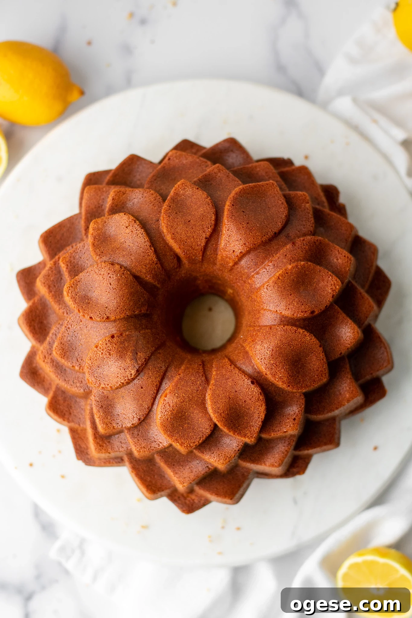 An overhead view of a lemon bundt cake in a blossom pattern.