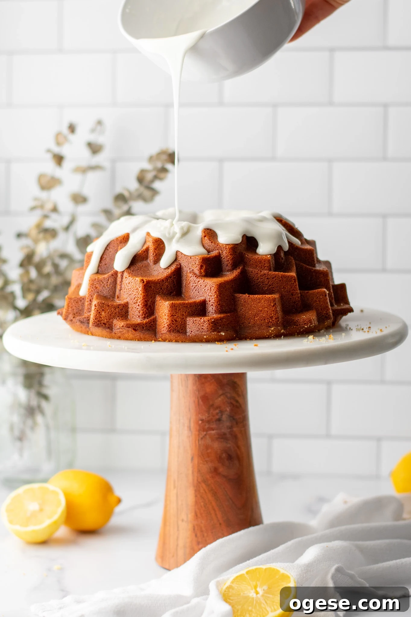 Adding icing to a lemon bundt cake.