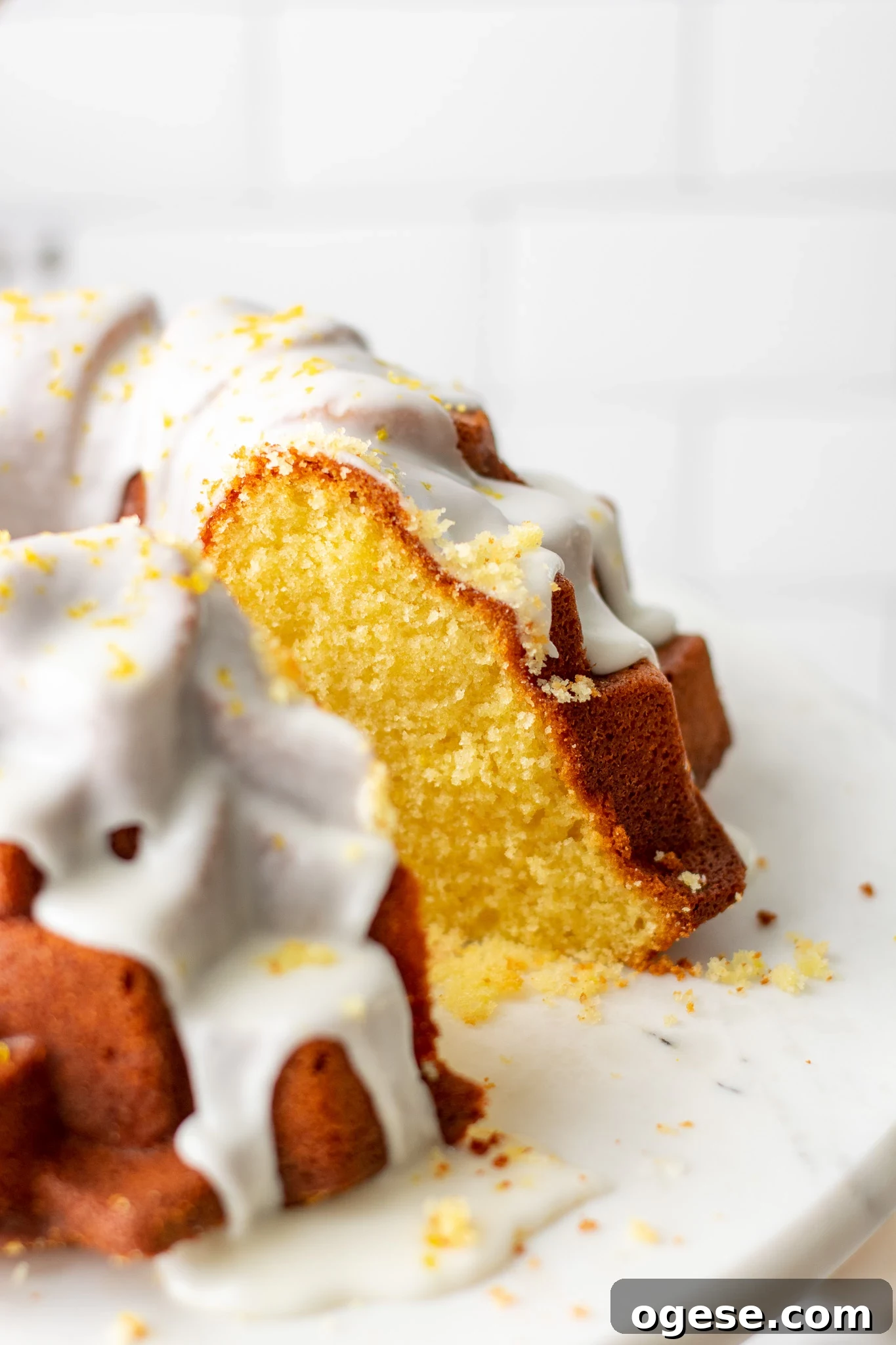 A slice cut out of a lemon bundt cake.