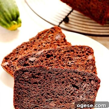 Moist Chocolate Zucchini Bread Recipe for Rich Homemade Loaves 2 Slices of chocolate bread on white plate.