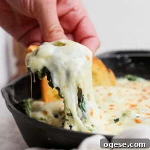 Classic Caprese Salad Recipe: Fresh Mozzarella, Tomatoes & Basil 10 A hand lifts a portion of cheesy spinach dip from a skillet.
