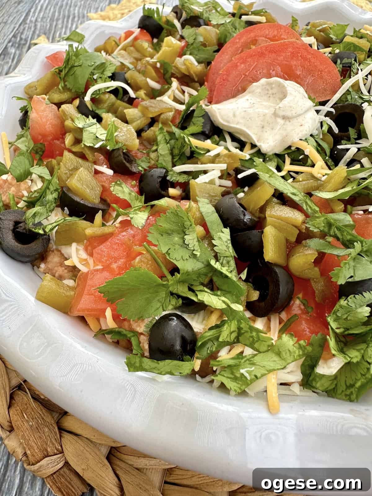 Creamy 5-Layer Bean Dip Recipe for Parties and Game Day 2 A dish of 5 layer bean dip.