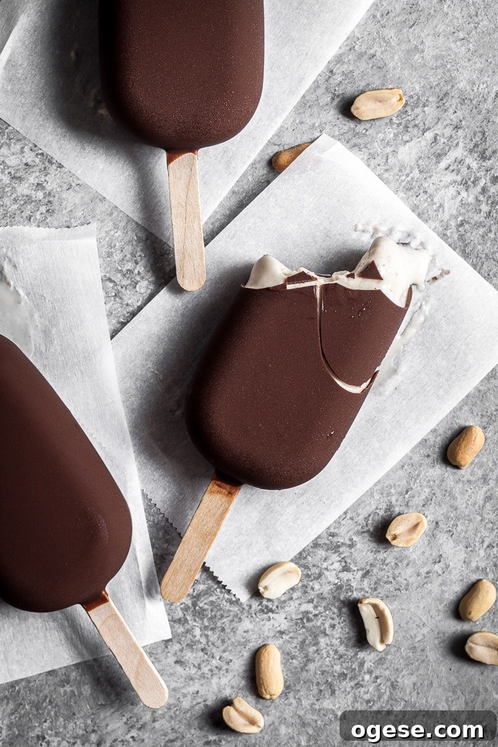 Three chocolate dipped ice cream bars with a bite taken out of one