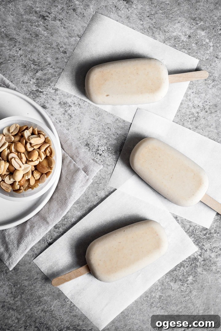 Peanut butter ice cream bars on parchment paper squares before dipping in chocolate