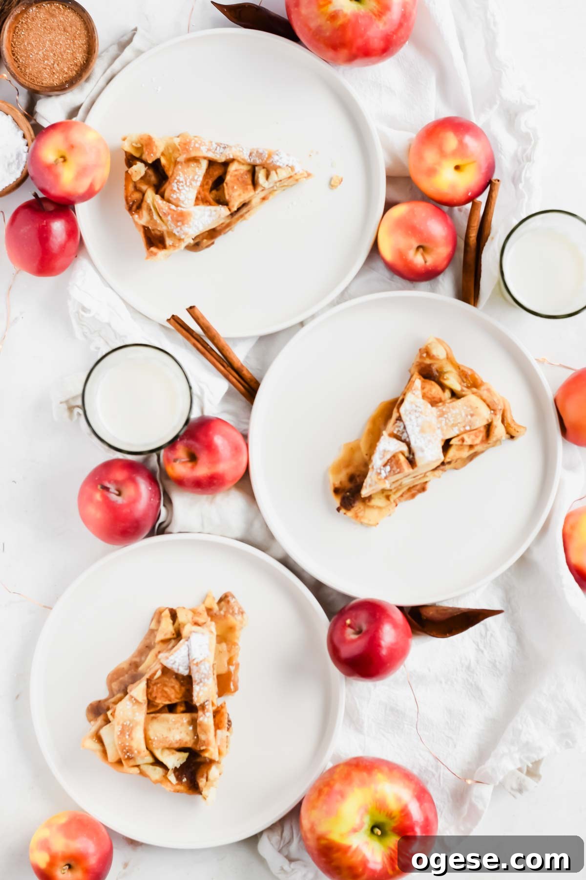 three slices of easy apple pie with store-bought crust topped with ice cream on white plates.
