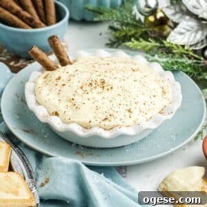 A bowl of eggnog dip on the table with a two pirouette cookies in it.