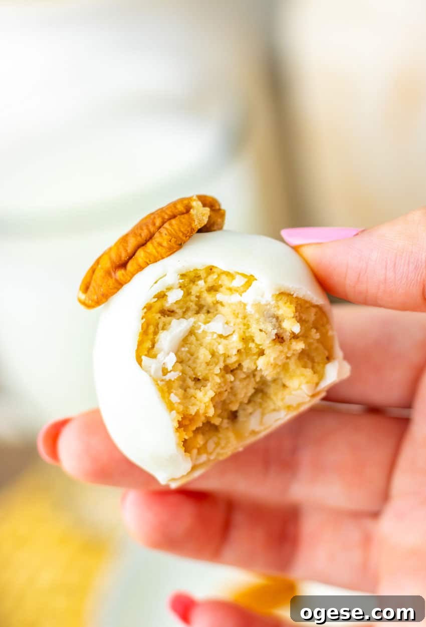 a hand holding up a bitten pecan pie truffle showing the inside filling