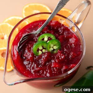Spicy Jalapeño Cranberry Sauce Recipe for Holiday Meals 7 glass serving bowl with Jalapeno Cranberry Sauce topped with sliced jalapeno garnish