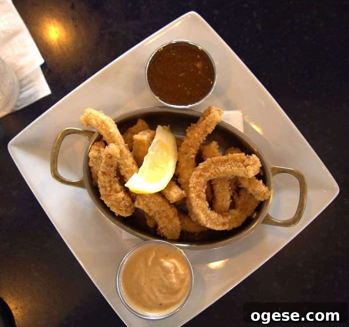 Charleston Travel Guide: Top Attractions, Food & Historic Tours 8 A white plate with breaded fried strips, a lemon wedge, and two dipping sauces in metal cups, photographed from above—perfect for any Charleston travel guide foodie adventure.