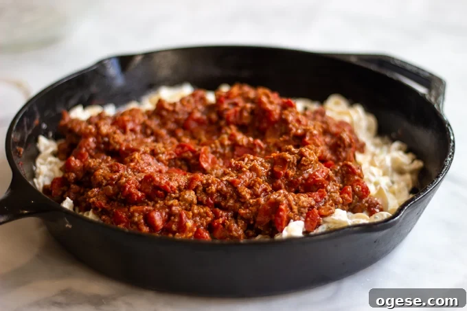 Homestyle Ground Beef and Egg Noodle Casserole (Video) 9 A skillet of egg noodles mixture topped with ground beef and tomato sauce