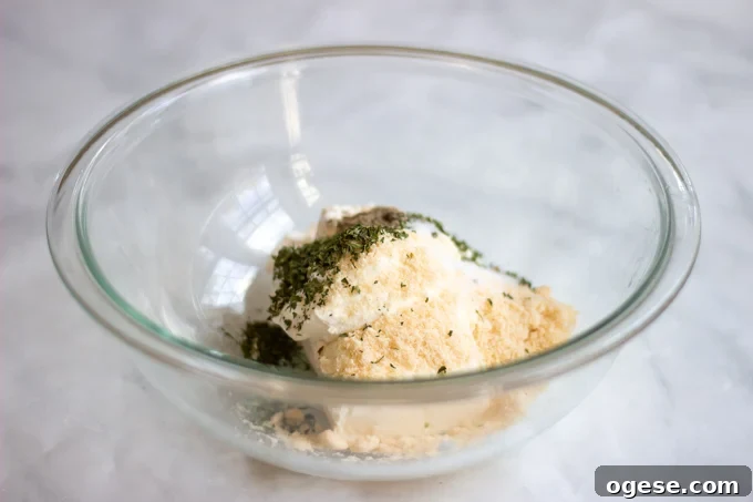 Homestyle Ground Beef and Egg Noodle Casserole (Video) 4 a bowl with cream cheese,sour cream, parmesan cheese and parsley.