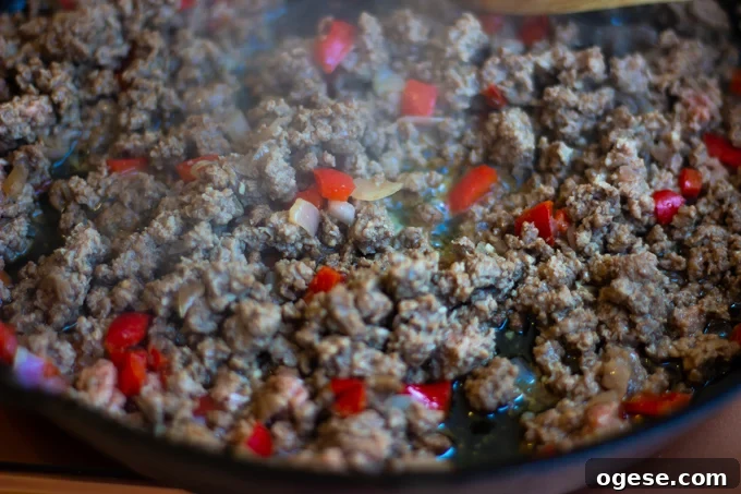 Homestyle Ground Beef and Egg Noodle Casserole (Video) 7 Ground beef browning in a skillet with onions and red bell peppers