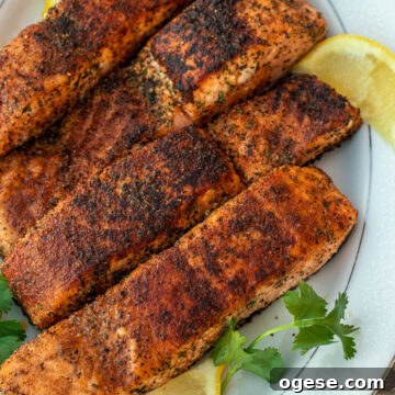 Four grilled salmon fillets on a serving platter