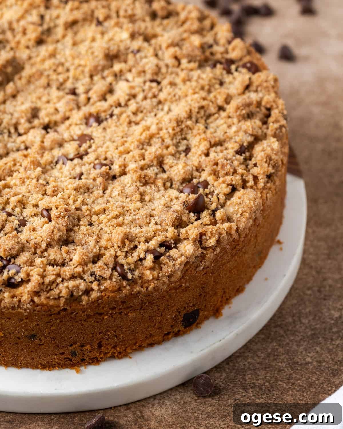 A freshly baked chocolate chip coffee cake sitting on a white marble serving board.