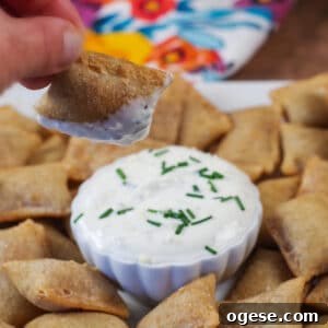 air fryer pizza bite being dipped over a tray of more air fryer pizza bites