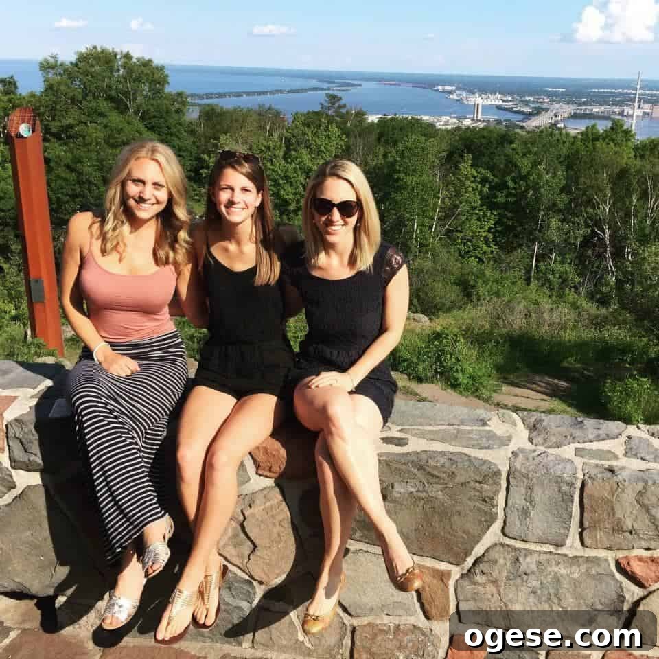 3 women sitting on rock wall