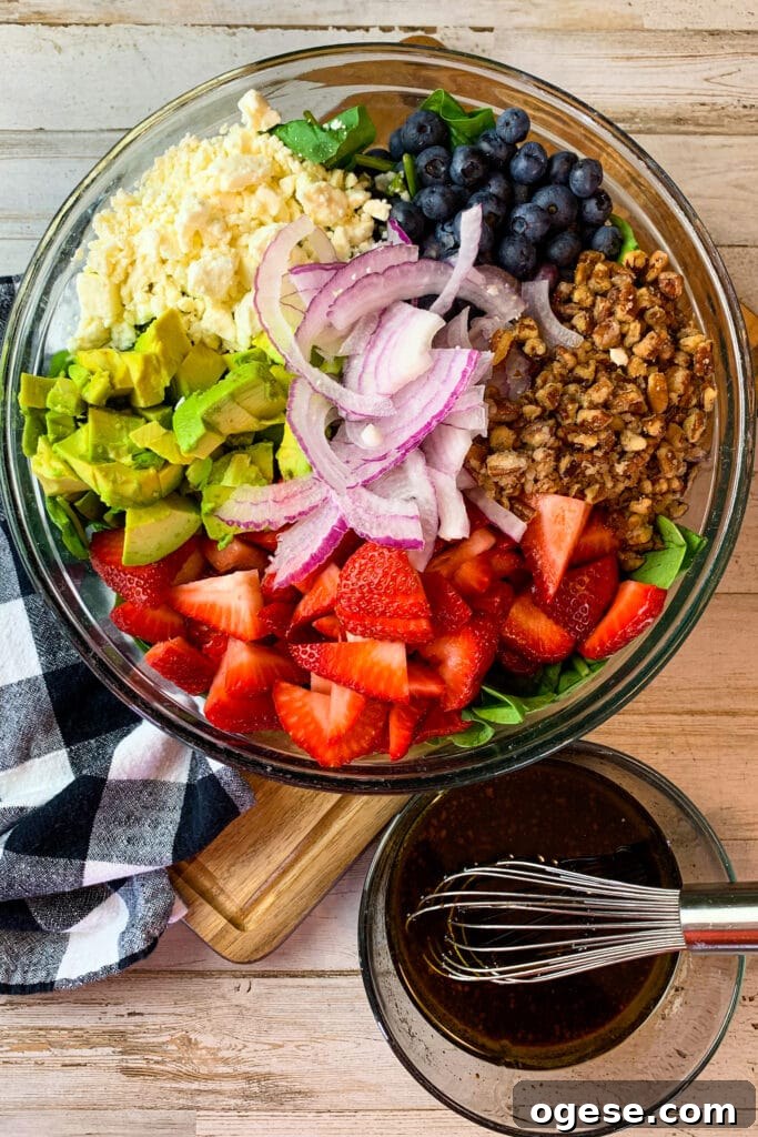All the ingredients needed to make strawberry spinach salad in a bowl.