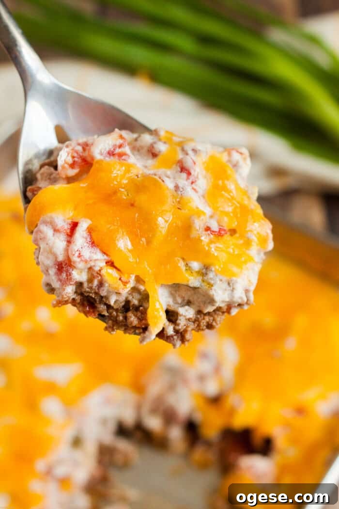 Low-Carb Taco Casserole with Cheesy Cauliflower Crust 14 keto casserole beef and tomato on spoon being served