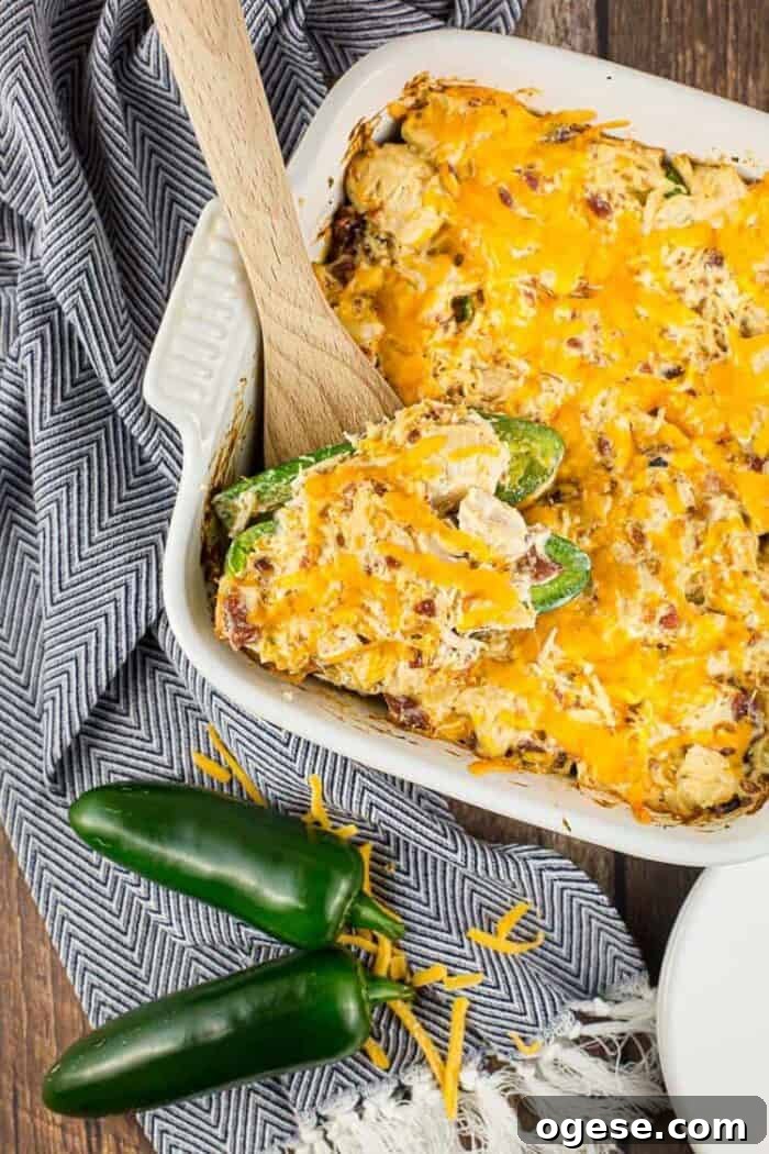 Low-Carb Taco Casserole with Cheesy Cauliflower Crust 24 white casserole dish containing keto jalapeño popper chicken casserole next to jalapeños