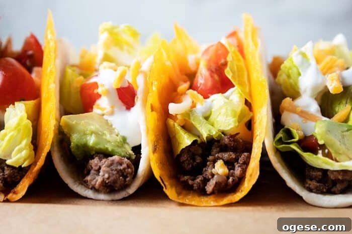 Low-Carb Taco Casserole with Cheesy Cauliflower Crust 10 2 cheese shell keto tacos and 2 tortilla keto tacos lined up together filled with meat, lettuce, tomato, sour cream and avocado