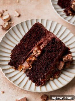 Decadent Twix Bar Cake Recipe with Caramel and Chocolate 12 Slice of twix cake on a plate.