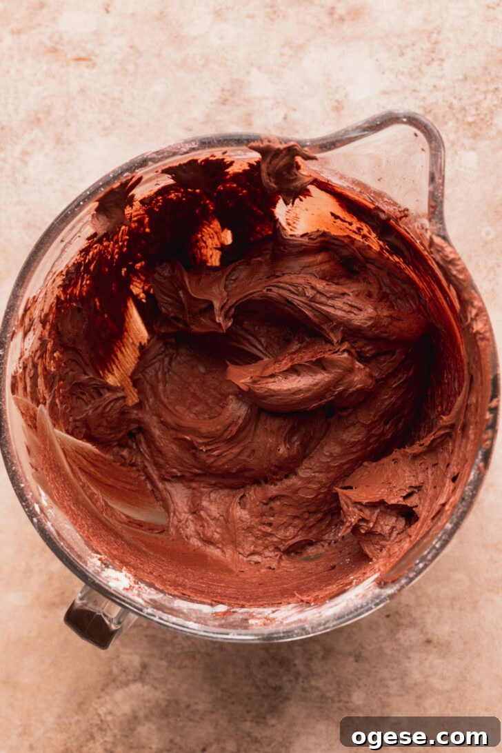 Decadent Twix Bar Cake Recipe with Caramel and Chocolate 6 Chocolate cream cheese frosting in a bowl.