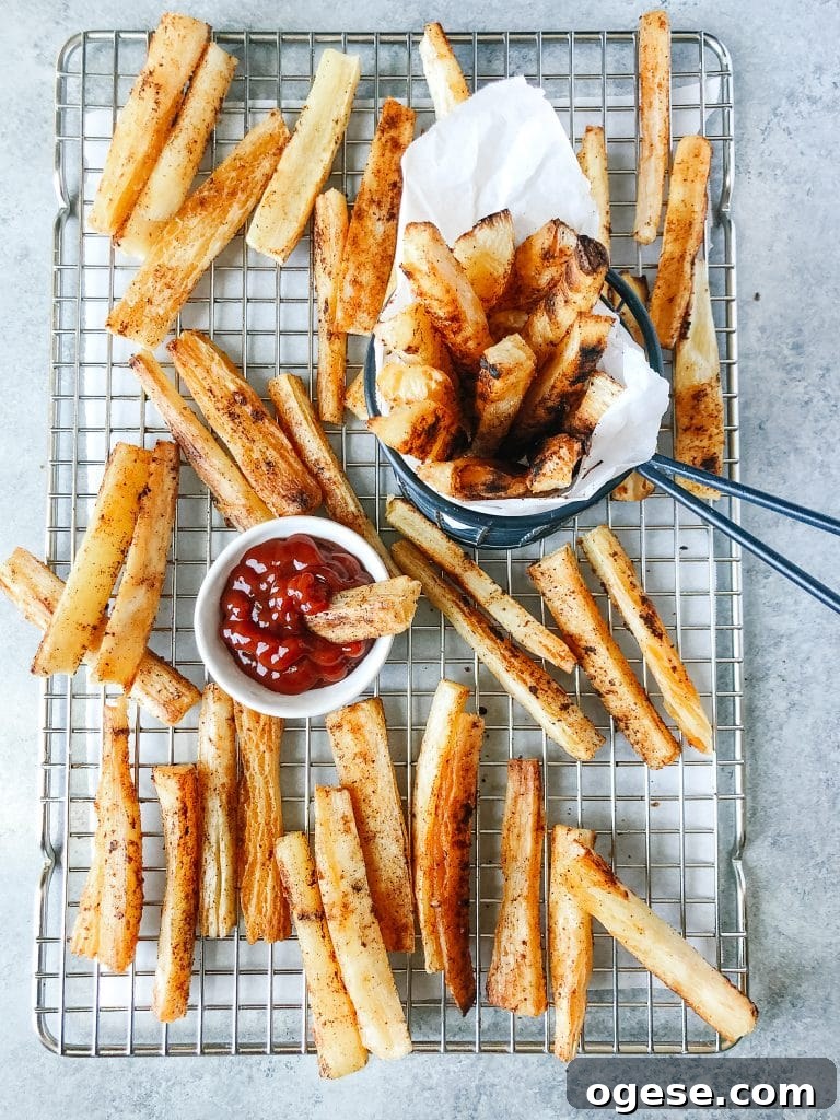 Crispy Baked Yuca Fries Recipe for Perfect Crunch 5 Baked yuca fries on a cooling rack with a small bowl of ketchup