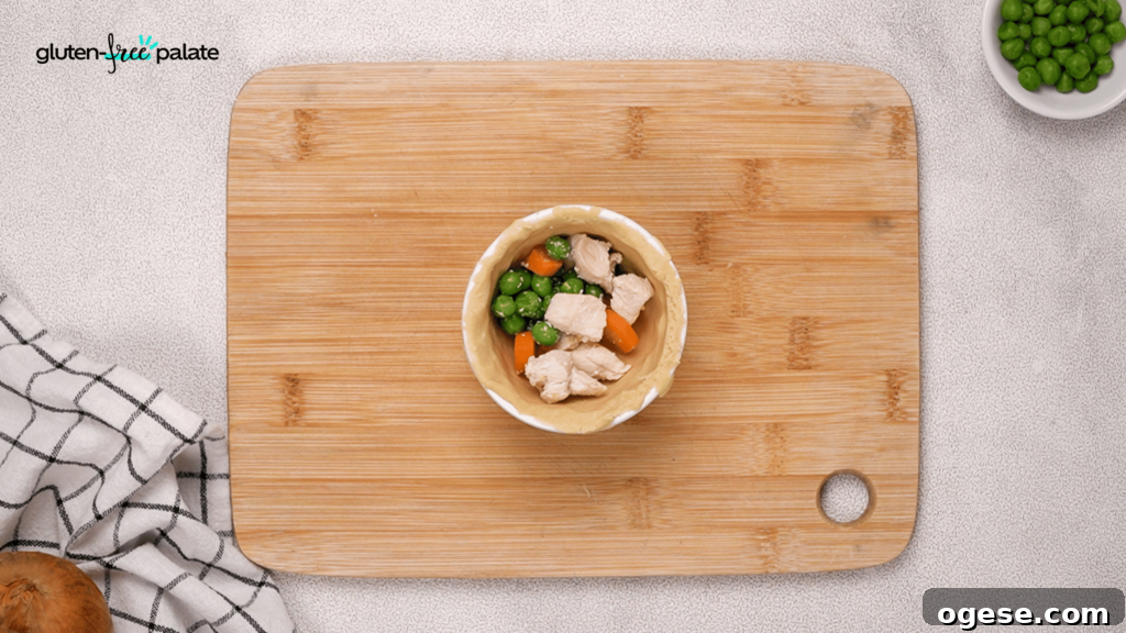Add your filling to the chicken pot pies. Next, you'll add the gravy.
