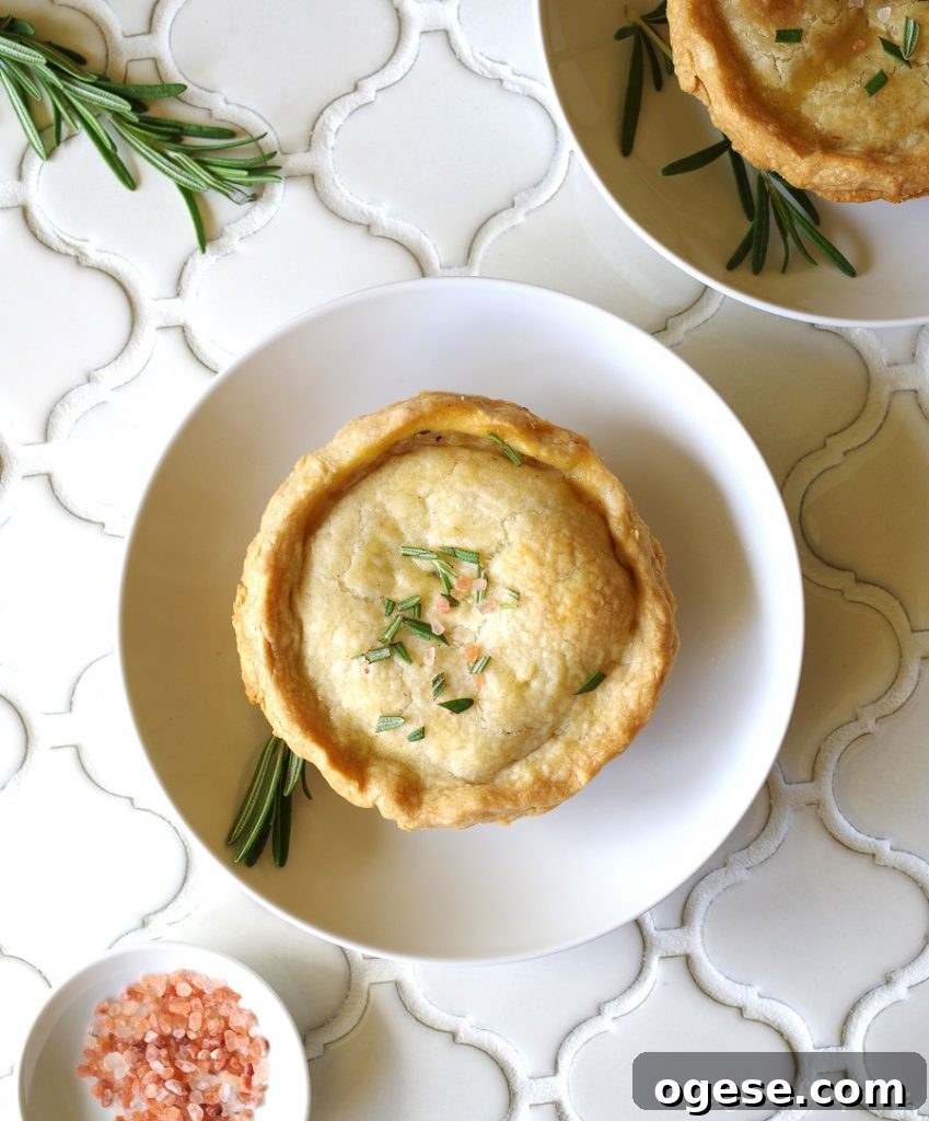 A Gluten-Free Chicken Pot Pie topped with salt and rosemary on a white plate