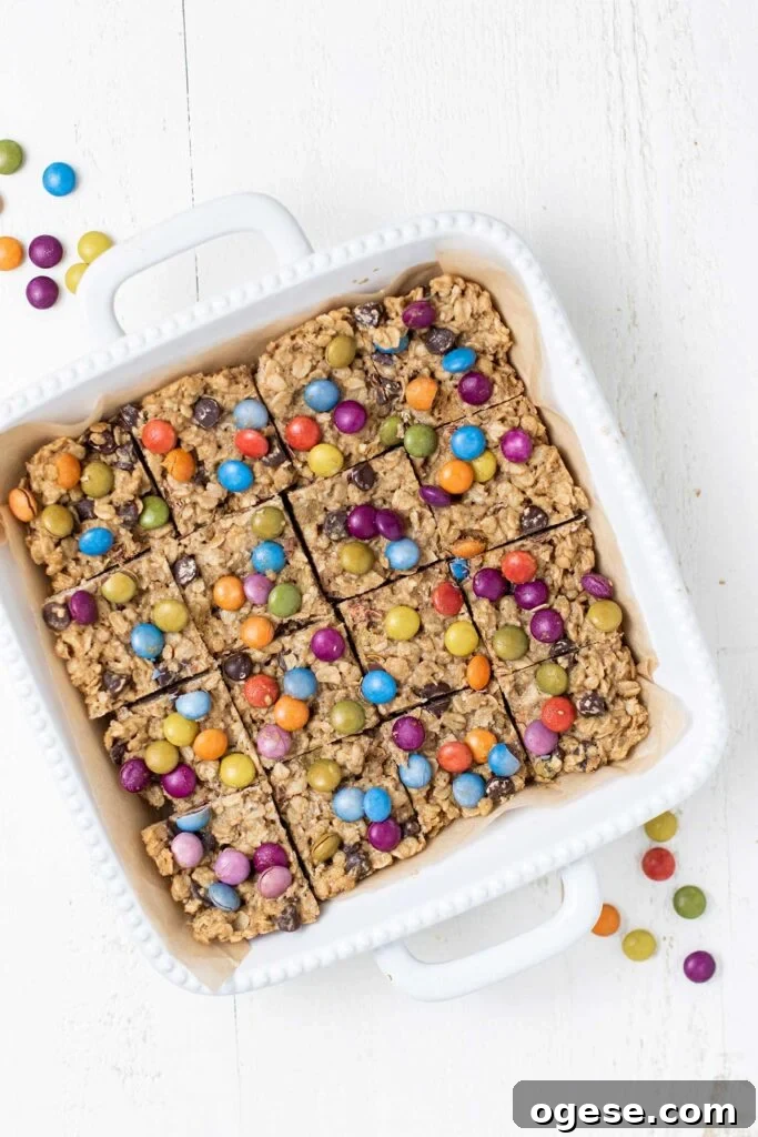 Chewy Monster Cookie Bars with M&Ms and Peanut Butter 7 A white baking dish with cookies cut into squares in it.
