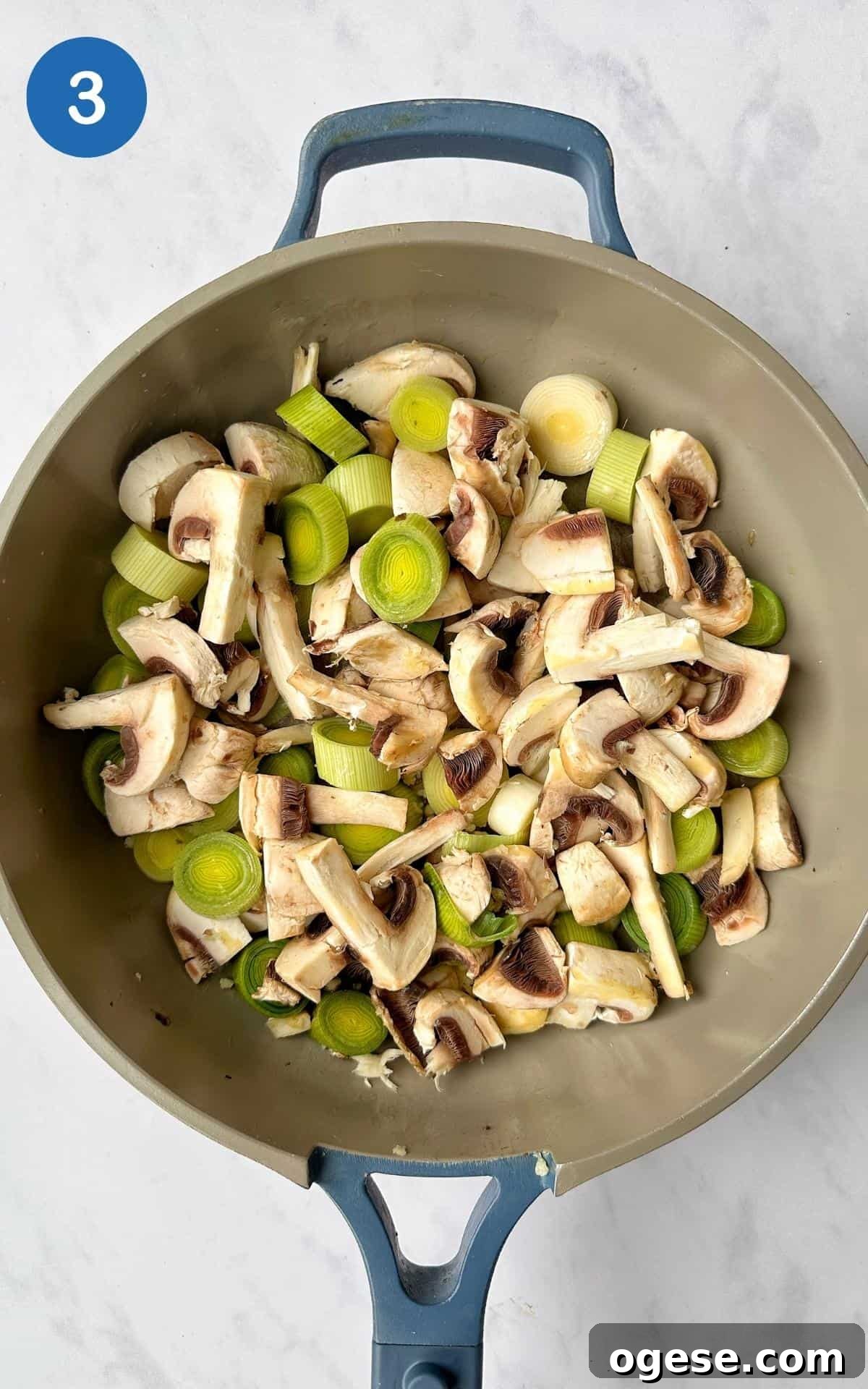 Chopped leeks and mushrooms frying in a non-stick frying pan.