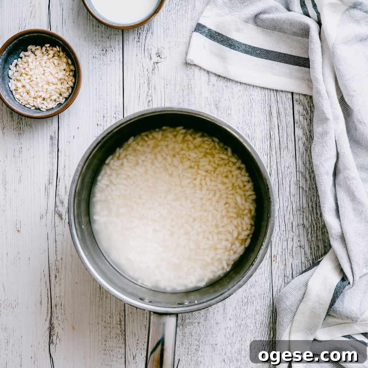 a pot of rice with water on a white table.