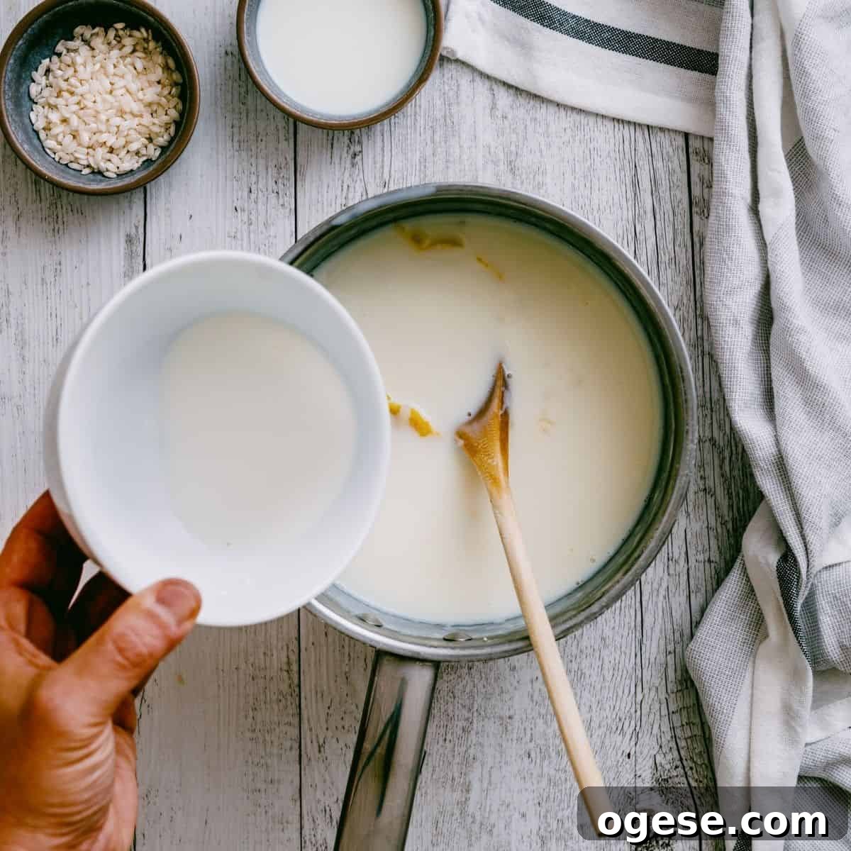 pouring a cornstarch slurry into a pot filled with rice pudding.