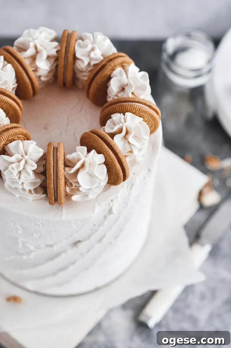 A view of the top of a vanilla cake with golden oreos and buttercream swirls