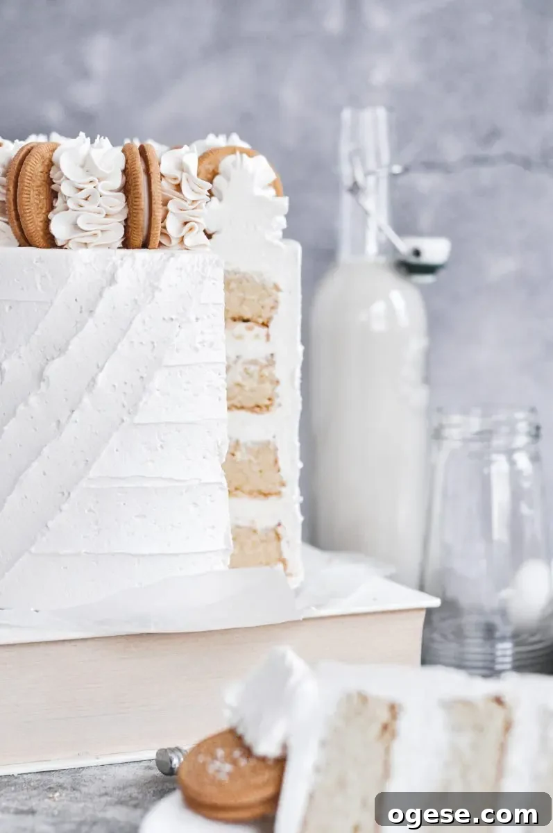 A white vanilla cake with white frosting and a slice cut out of it.