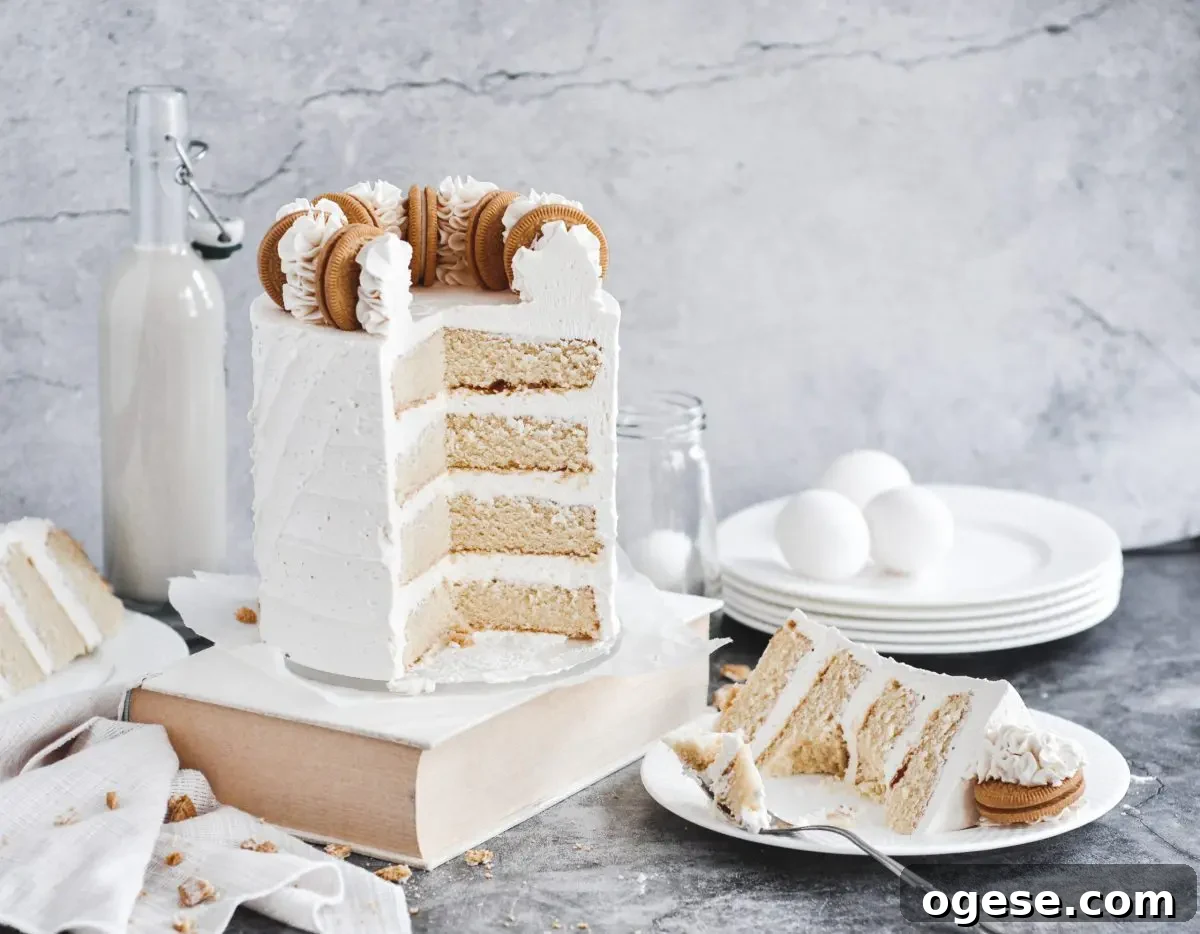 A white vanilla cake with a slice cut out and the cake slice on a white plate sitting beside it
