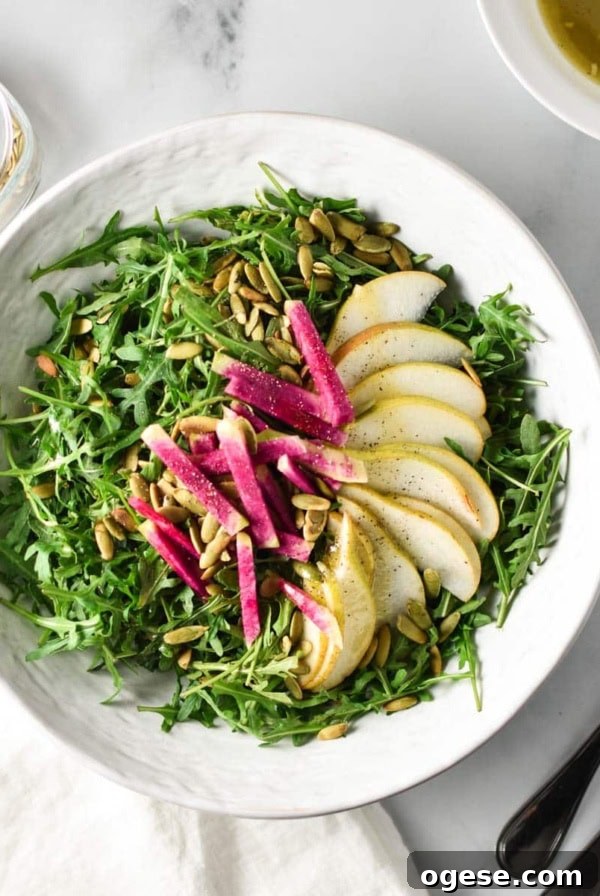 Crisp Bibb Lettuce Salad with Lemon Vinaigrette 11 A rocket and pear salad next to dressing and pepitas.