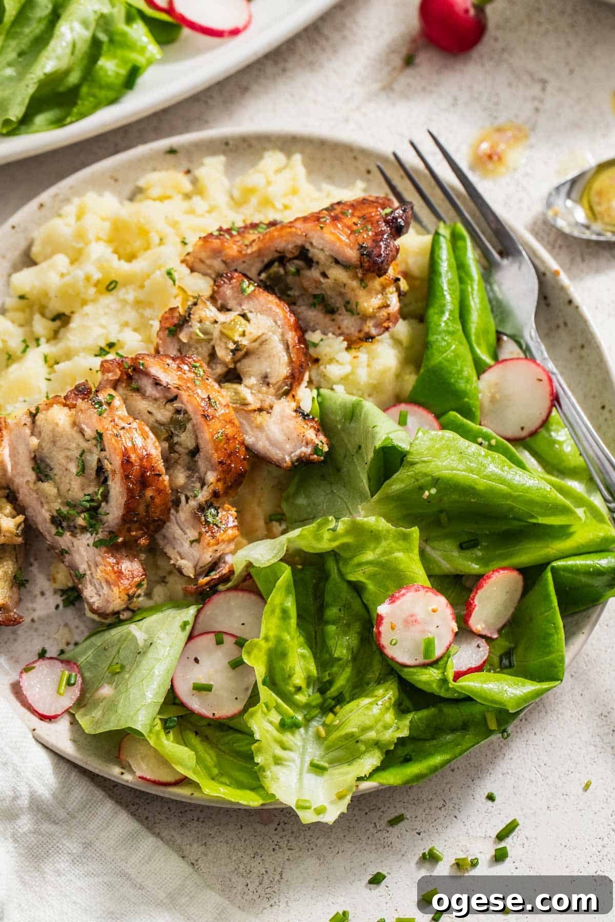 Crisp Bibb Lettuce Salad with Lemon Vinaigrette 7 A butter lettuce side salad next to stuffed pork chops and mashed potatoes.