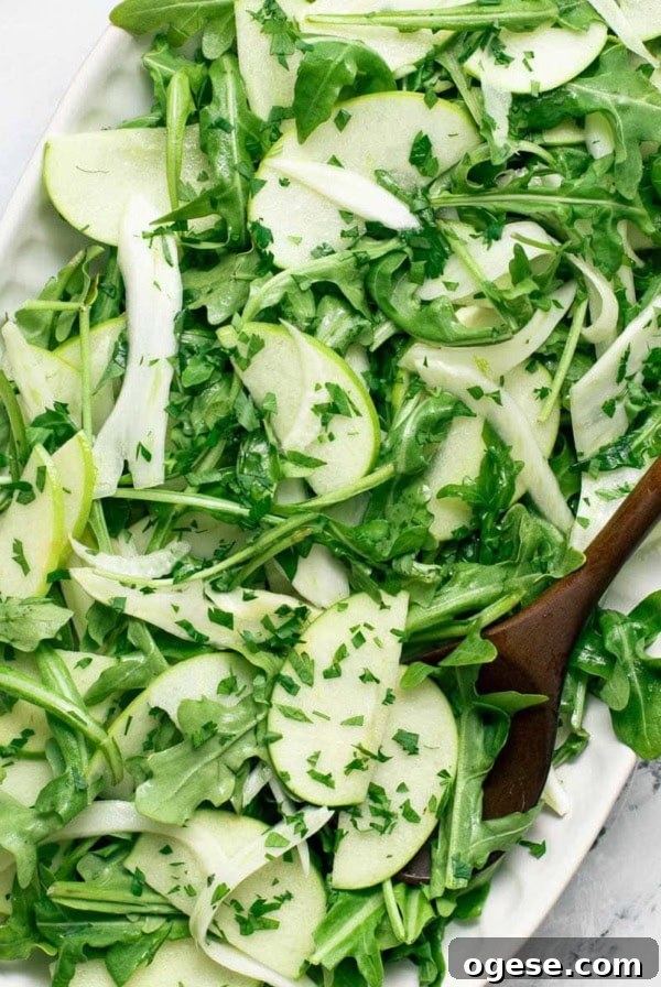 Crisp Bibb Lettuce Salad with Lemon Vinaigrette 9 Apple fennel salad on a serving platter with a wood spoon.